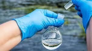 photo of a surgical gloved hand testing water